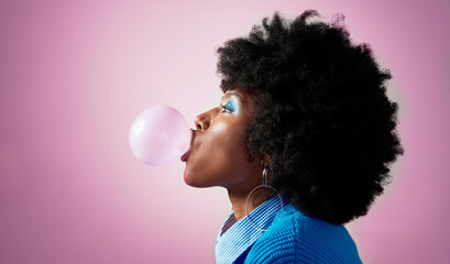 Bubble gum, afro hair and black woman on pink studio background with fashion, cool or Jamaican...