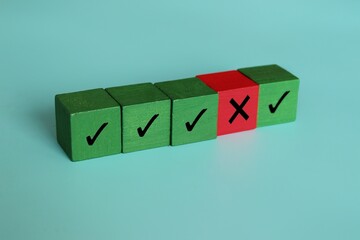 Wooden cubes with right and wrong icon. Violation contract terms, termination, corruption, failure...