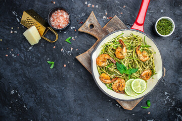 zucchini pasta with shrimps and pesto sauce in pan. keto low carb diet. banner, menu, recipe place for text, top view