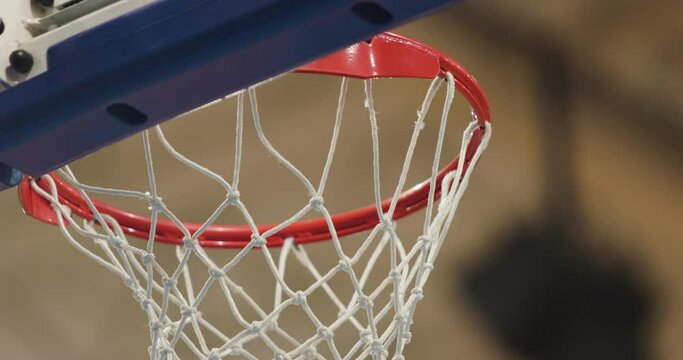 Abstract closeup basketball ring during practice. One ball scoring one ball missing the hoop.