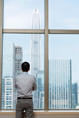 Fototapeta premium Businessman standing in front of the window