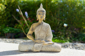 Buddha statue near house in front of garden.