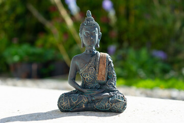 Buddha statue near house in front of garden.