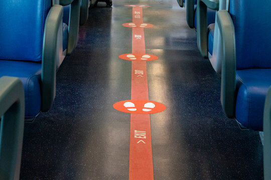 Exit sign on the floor of a commuter train car with seats. In case of danger, the sign shows where people need to move. Safety concept