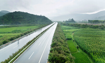 Empty highway through green fields