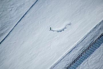 Foto op Canvas Aerial view of a man skiing on the mountain snow © Szász Máté/Wirestock Creators