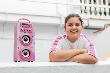 Cheerful teenager near pink speaker