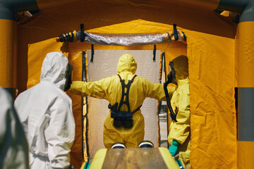Members of biohazard teams of fire brigade and emergency medical service in protective suits..