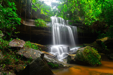 A small waterfall in the deep forest of the border of Thailand and Cambodia,ASIA.Khun Sri waterfall in tropical forest,Sisaket province,Thailand. Leaf moving low speed shutter blur.