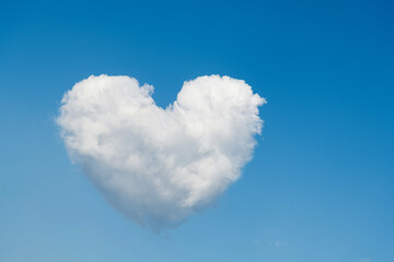 Naklejka na ściany i meble White heart shaped cloud in the blue sky