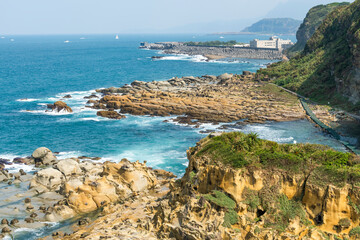 Fototapeta premium The landscape of the coastal rock and Arabao Bay at Heping Island Park in Keelung City, Taiwan.