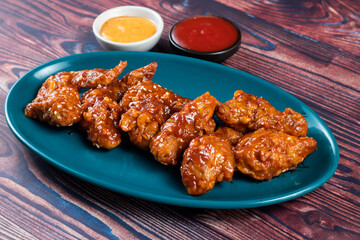 crispy chicken wings with ketchup and mayo dip served in dish isolated on background top view