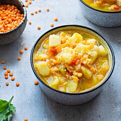 Soup with red lentils and vegetables in a bowl on a blue background.Traditional dish of Turkish or Arabic cuisine, vegan healthy food.