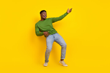 Fototapeta na wymiar Full length body size view of attractive carefree cheerful guy playing invisible guitar isolated on bright yellow color background