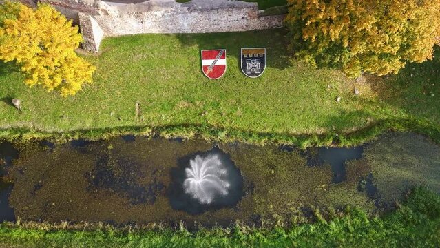 Aerial View of the Dobele City, Ancient Medieval Castle Park With Fontain Latvia. Aerial Panorama of Dobele City Sunny Autumn Day Landscape 4K. Camera Moves Sideward