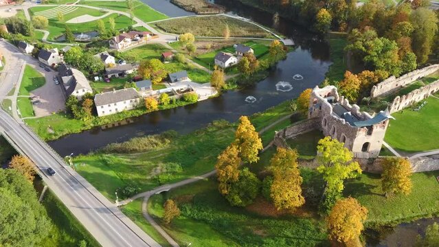Ruins of an Ancient Medieval Castle Dobele Latvia, Aerial Panorama of Dobele City, Berze River With Fontains and Medieval Castle Ruins With Restored Capella, Latvia. Sunny Autumn Day 4K