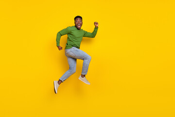 Fototapeta na wymiar Full length body size view of attractive cheerful funny guy jumping running isolated over shine yellow color background