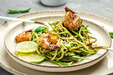 Pasta spaghetti zucchini basil pesto sauce and grilled shrimp, Vegetarian vegetable pasta, Food recipe background. Close up