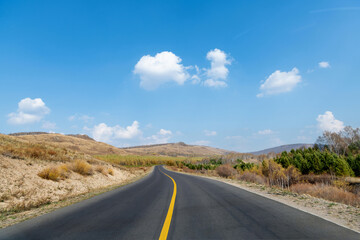 Country road through the hill in the autumn