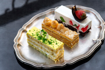 Set of tasty elegant desserts served on silver platter