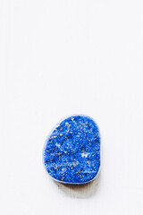 Galet pierre roulée polie lapis-lazuli sur un fond blanc avec espace vide - Minéral naturel