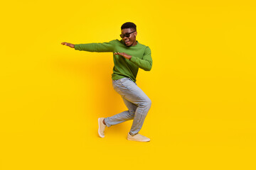 Full length body size view of attractive cheery guy dancing fooling having fun isolated on bright yellow color background