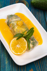 Spring roll served with yellow sauce, lemon and mint