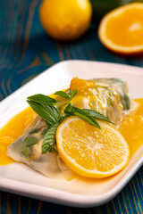 Spring roll served with yellow sauce, lemon and mint