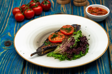 Homemade baked eggplant served with cherry tomatoes, pepper and chili sauce