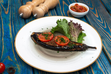 Homemade baked eggplant served with cherry tomatoes, pepper and chili sauce