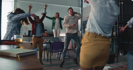 Camera moves around crazy office party, happy business people celebrating raise and success at workplace.