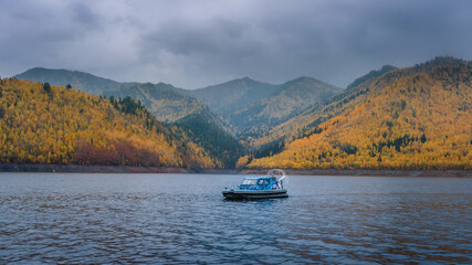 an airboat in a river bay. Boat on the sea. Yellow autumn forest in the mountains
