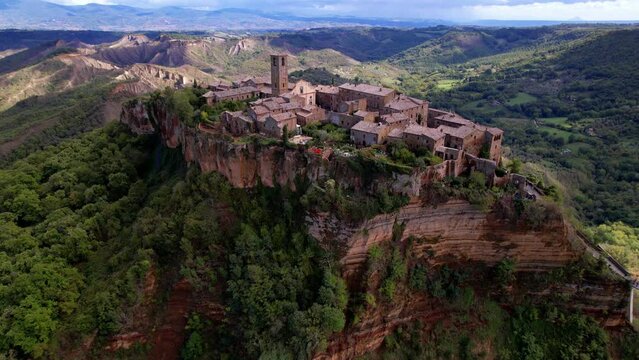 Civita di Bagnoregio. Aerial 4K Italian ghost town fly over. Cinematic drone over ancient stone town on tuff cliff edge with canyon views. Lazio heritage scenery. Italy, Lazio region, Viterbo province