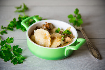 Potato dumplings with onion and mushrooms in a plate.