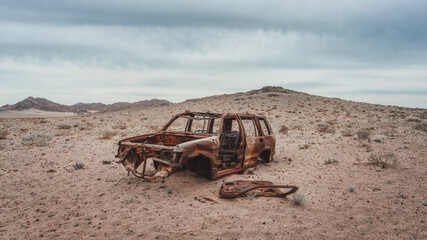 a burnt-out pickup truck in the desert. Burned abandoned car