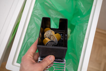 throwing coffee capsules in the trash bin