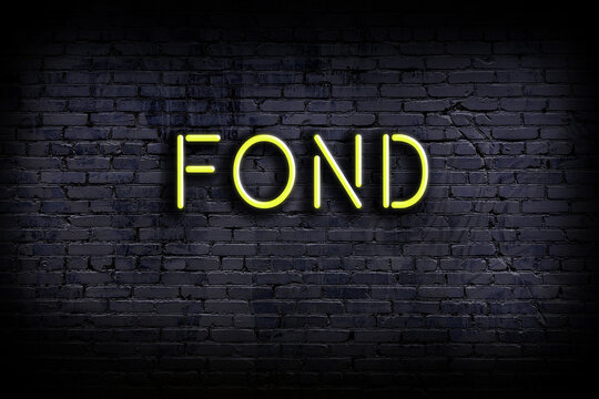 Neon sign. Word fond against brick wall. Night view