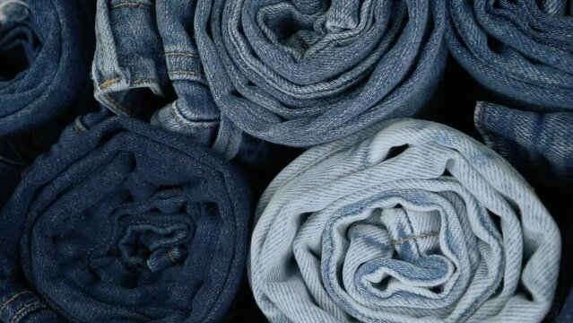 Monochromatic blue video footage of rolled up denim jeans. Blue jean fabric texture.
