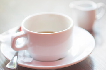 Defocused view of white cup of hot coffee