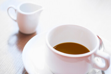 Defocused view of white cup of hot coffee
