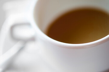 Defocused view of white cup of hot coffee