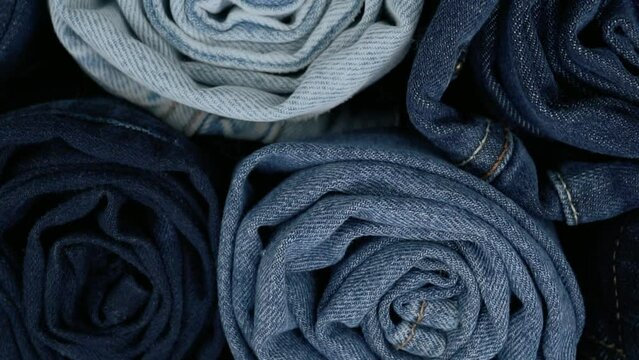 Monochromatic blue video footage of rolled up denim jeans. Blue jean fabric texture.