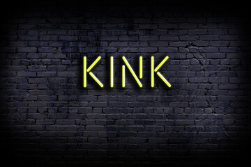 Night view of neon sign on brick wall with inscription kink