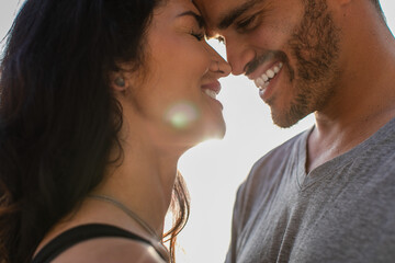 portrait of happy man and brunette woman with closed eyes smiling outside.