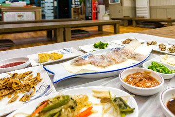 Delectable plate of raw fish freshly sliced and side dishes at the table of a restaurant, close-up view