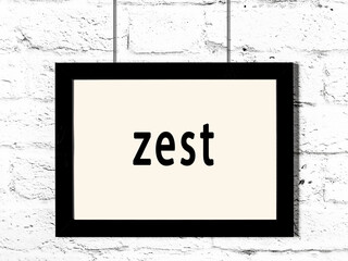 Black frame hanging on white brick wall with inscription zest