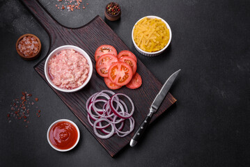 Raw ingredients for delicious Italian pasta: tomatoes, minced meat, pasta, spices and herbs