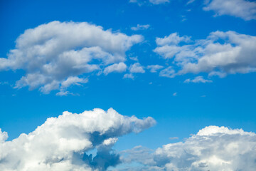 Fototapeta premium Sky background - white clouds on a bright blue sky gather into puffy clouds.