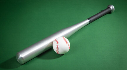 Baseball bat and baseball on the green background.