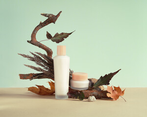 Set of empty cosmetic packaging, jar and bottle, mockup, against the background of autumn props. Autumn modern still life.